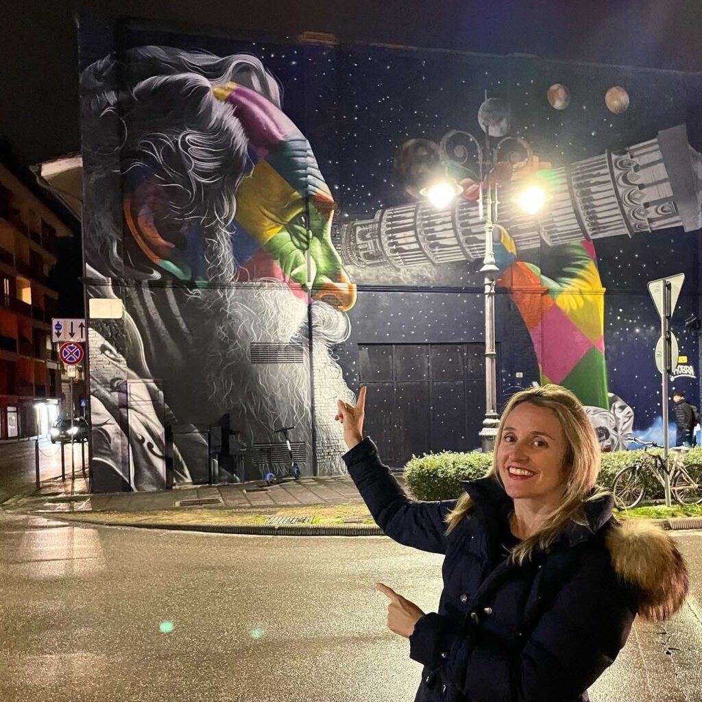Eduardo Kobra in Pisa: The Story Behind the Brazilian Mural That Enchants Tuscany 3 barbara bueno in front of mural by kobra in pisa