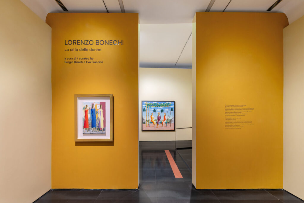 Museo del Novecento in Florence 7 Entrance to the exhibition Lorenzo Bonechi – La città delle donne at Museo Novecento, Florence, with a yellow wall, a painting of women on display, and another artwork visible in the background.