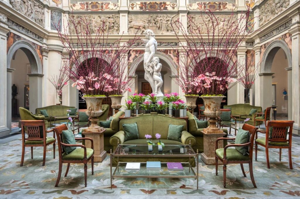 The 7 Best Luxury Hotels in Florence 11 Impressive central hall at Four Seasons Hotel Firenze with Renaissance statues, floral arrangements, and elegant seating.