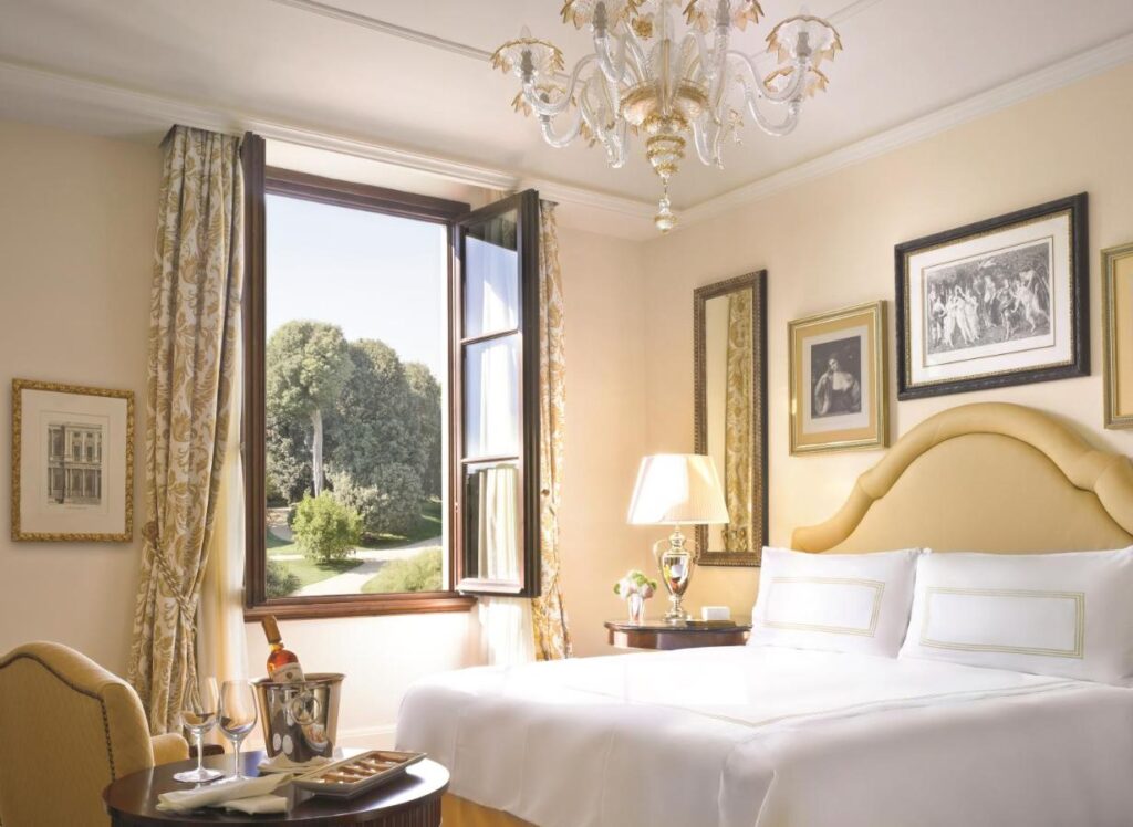 The 7 Best Luxury Hotels in Florence 13 Charming room at Four Seasons Hotel Firenze with garden view, golden headboard, and classic Italian atmosphere.