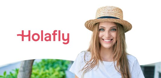 Stay Connected in Tuscany: Why Choose Holafly eSIM - Smiling young woman wearing a straw hat and holding a smartphone, standing outdoors next to Holafly’s logo—representing easy eSIM connectivity for travelers.
