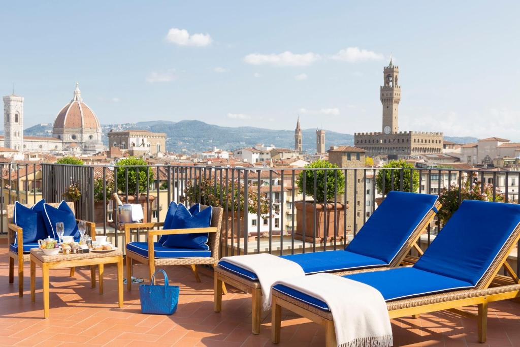 The 7 Best Luxury Hotels in Florence 19 Rooftop terrace at Hotel Lungarno with blue sun loungers and panoramic view of Florence, including the Duomo and Palazzo Vecchio