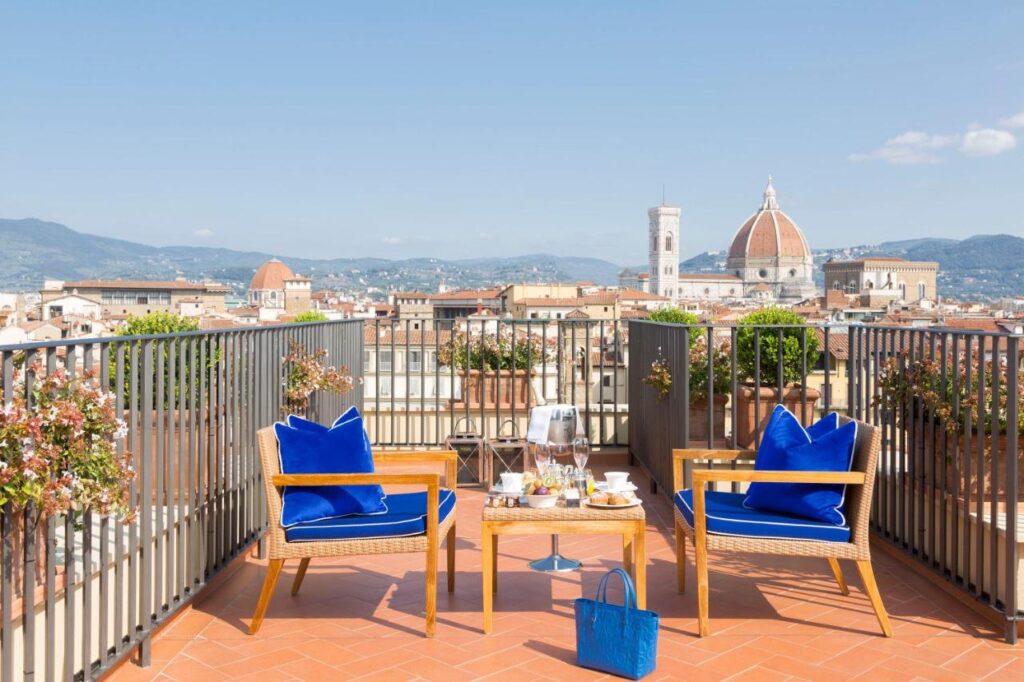 The 7 Best Luxury Hotels in Florence 16 Riverside terrace at Hotel Lungarno in Florence with happyhout tables overlooking the Arno River and historic bridges.