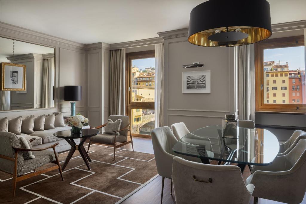 The 7 Best Luxury Hotels in Florence 28 Luxury suite at Portrait Firenze featuring a stylish dining area, elegant living room, and large windows with views over Florence.