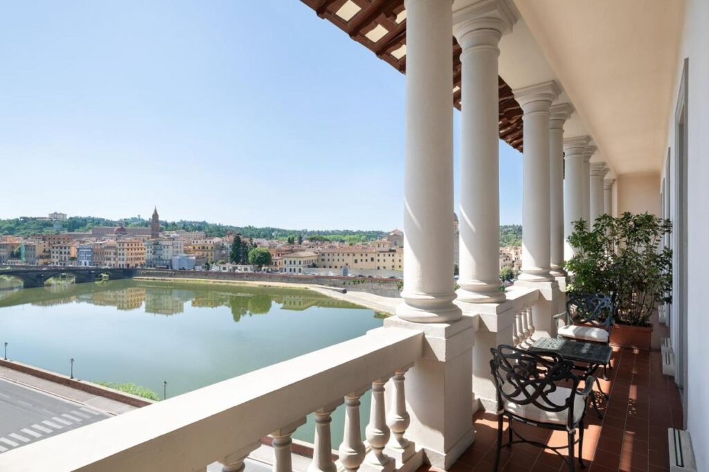 The 7 Best Luxury Hotels in Florence 1 Scenic terrace at The St. Regis Florence with elegant columns, wrought iron chairs, and a breathtaking view over the Arno River and Florentine cityscape.