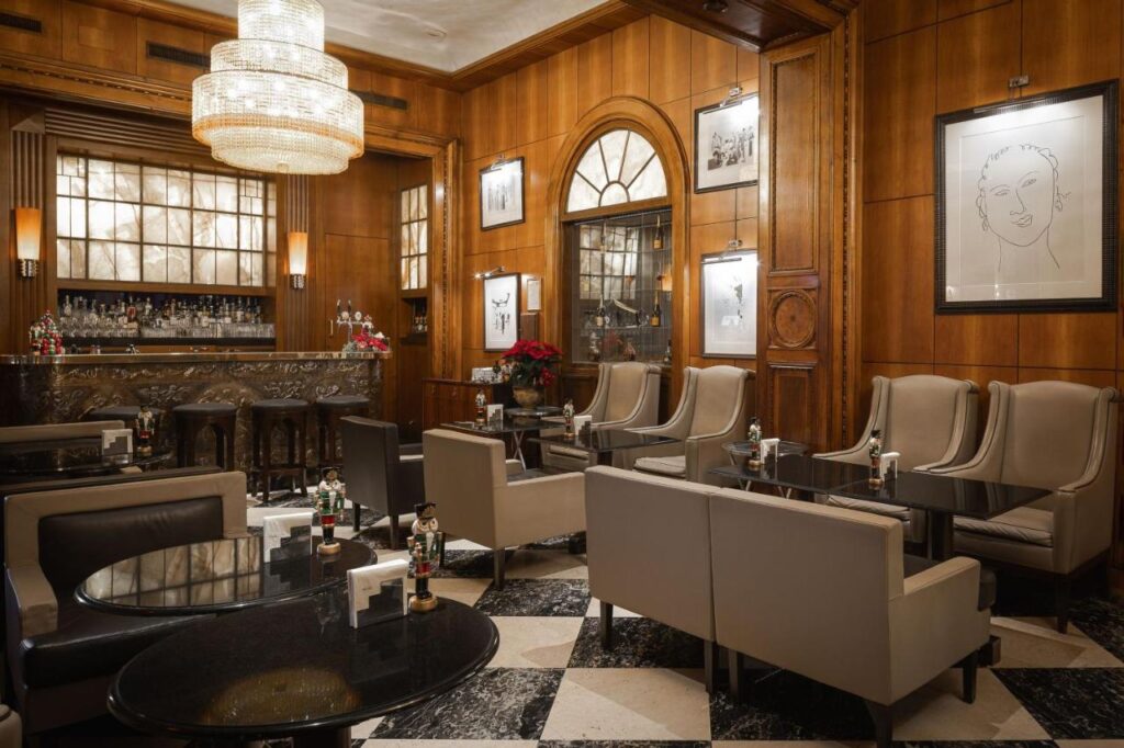 The 7 Best Luxury Hotels in Florence 32 Stylish bar at The Westin Excelsior Florence featuring a crystal chandelier, marble bar, and refined seating area.