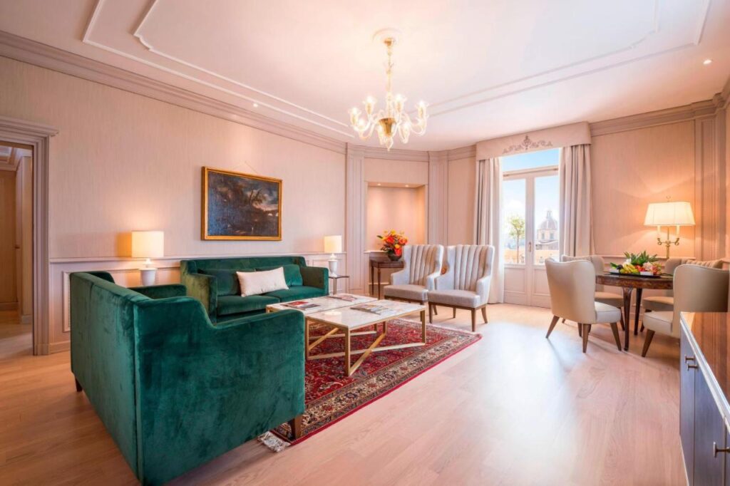The 7 Best Luxury Hotels in Florence 35 Elegant suite living room at The Westin Excelsior Florence with green velvet sofa, classic decor, and city views.