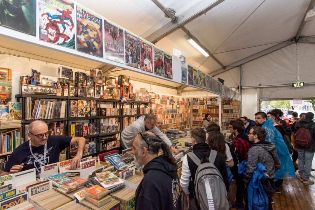 Visitors browsing comic books and collectibles inside an exhibition tent at Lucca Comics & Games.