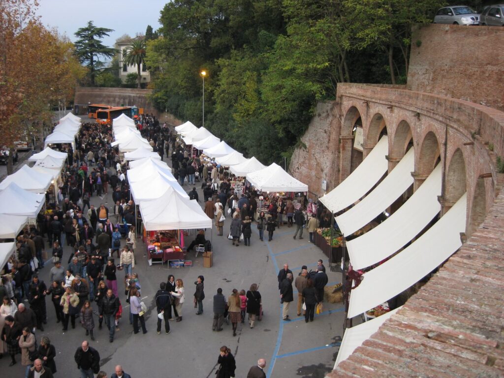 Outdoor truffle market in San Miniato, Tuscany, with crowds and white tents.