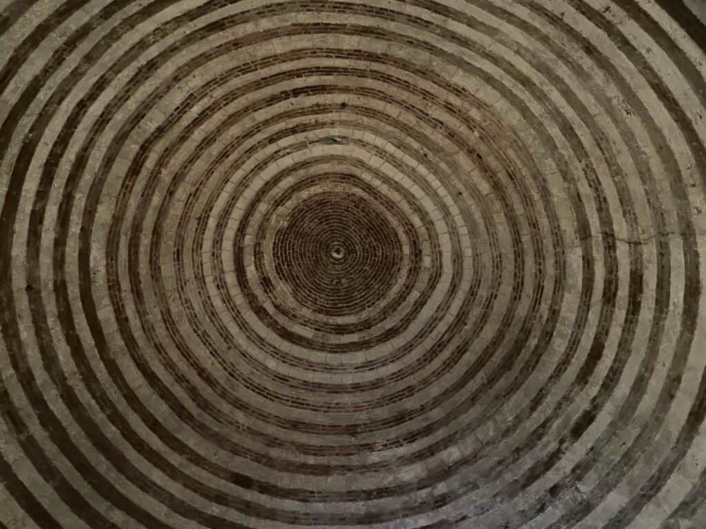 Ceiling of Montesiepi Chapel in Tuscany with red and white concentric rings.
