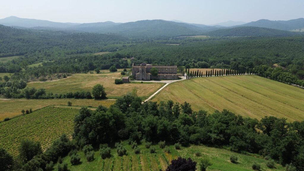 Aerial view of San Galgano Abbey in Tuscany surrounded by greenery.