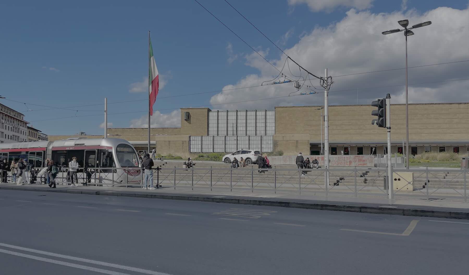 Modern tram in front of Santa Maria Novella railway station in Florence, Italy, on a sunny day.