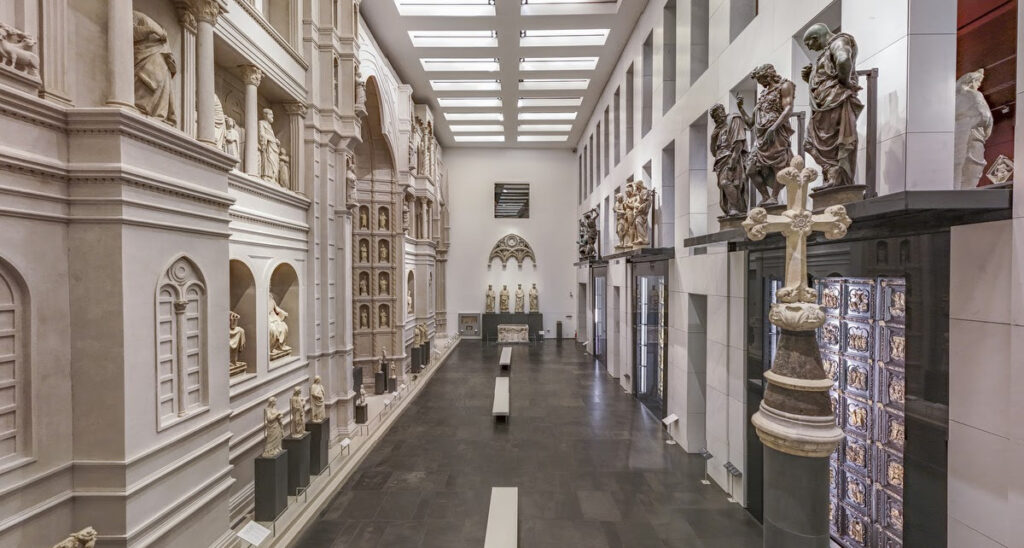 Interior view of the Opera del Duomo Museum in Florence with statues, reliefs, and architectural models from the Cathedral.