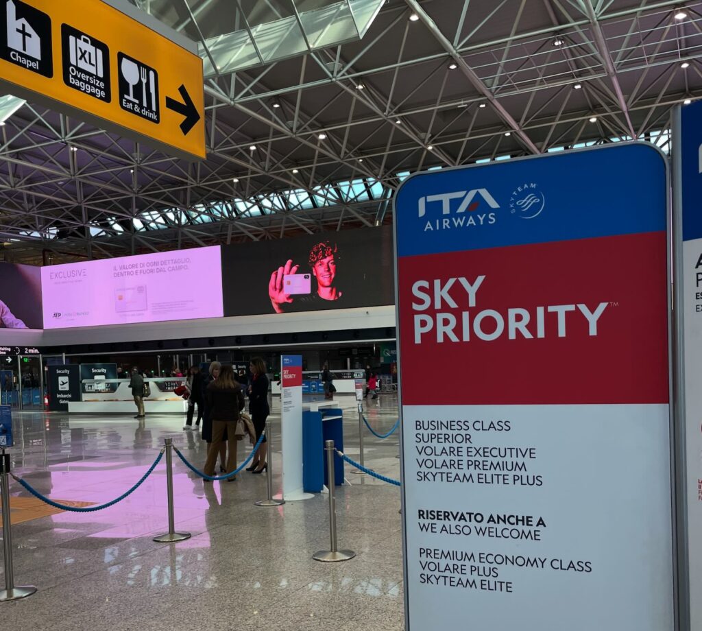 ITA Airways Sky Priority area at the airport, with a sign for Business Class and Premium Economy, used in the article about the ITA Airways promo code SCONTOAL20 (20% off).
