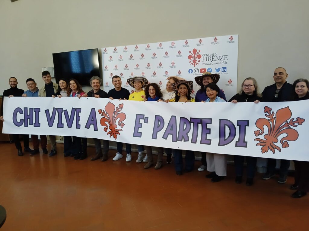 Florence's Carnevale di Pace Returns: A Vibrant Celebration of Peace, Rights, and Inclusion 1 Carnevale di Pace Florence participants holding inclusion banner "Those who live in Florence are part of Florence" at Comune di Firenze press event, featuring multicultural community representatives