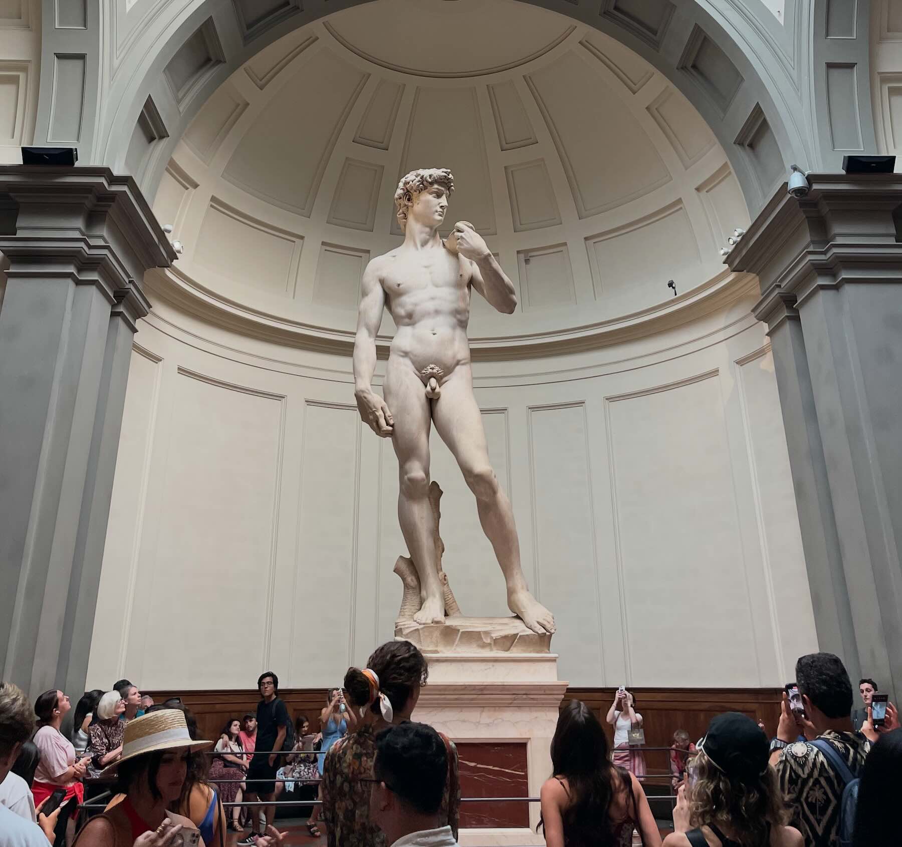 Tourists admiring Michelangelo's David statue at the Galleria dell'Accademia in Florence, Italy