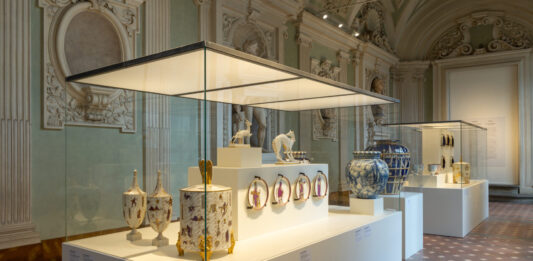 Decorative ceramic pieces displayed in glass cases at the Firenze Déco exhibition inside Palazzo Medici Riccardi in Florence