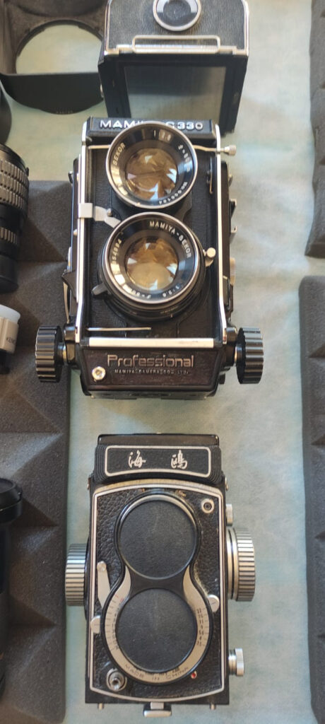 Close-up of vintage twin-lens reflex cameras displayed on a table at Foto Antiquaria in Arezzo.