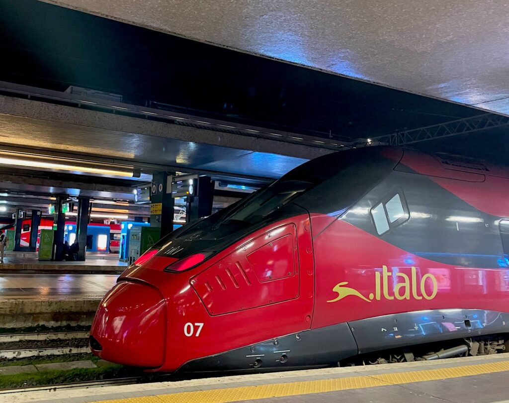 Italo 2x1 Train Deal in Italy: Save on Train Travel to Florence and Tuscany - Red Italo high-speed train at the platform of Santa Maria Novella station in Florence, Tuscany