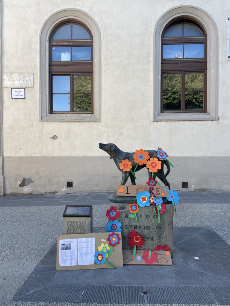 Fido's Statue in Borgo San Lorenzo: The Story of Tuscany's Most Loyal Dog 3 Fido's statue decorated with colorful paper flowers made by local students, Borgo San Lorenzo