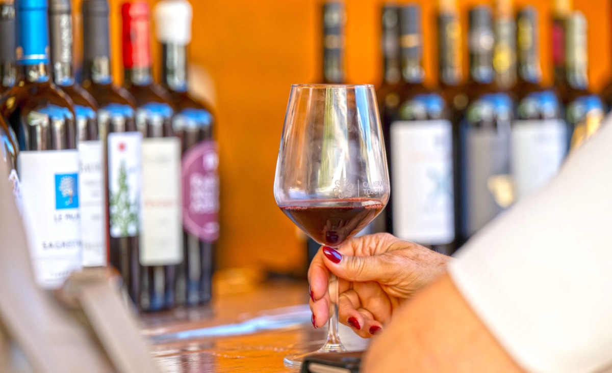 Terre di Pisa Food & Wine Festival 2026: Tastings Beyond the Leaning Tower 1 Glass of red wine in front of bottles from Pisa-area wineries, promotional image of the Terre di Pisa Food & Wine Festival